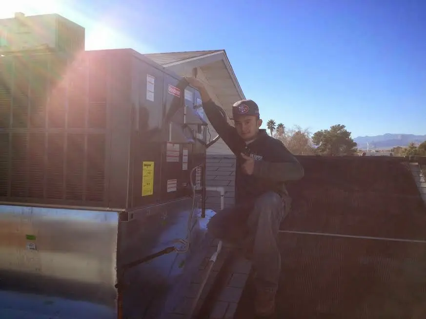 HVAC technician performing Heat Pump Repair on a rooftop unit in Williamsburg